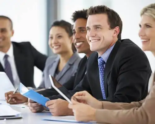 Business people in a meeting, smiling.