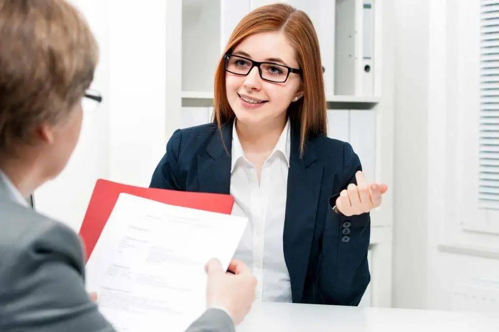 Woman in suit talks to a person.