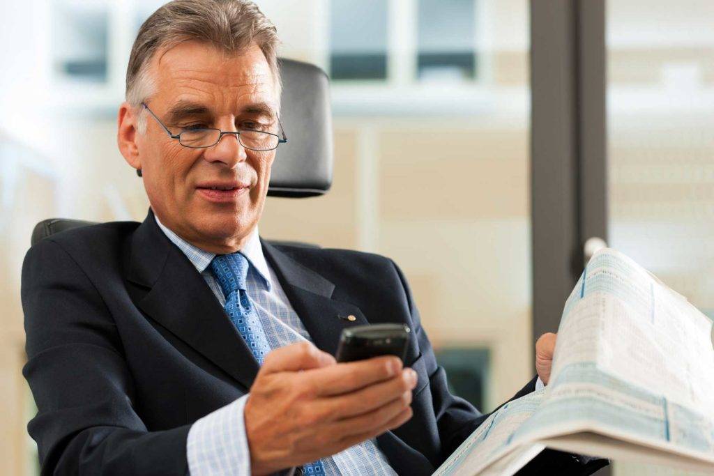 Personal Recognition Businessman in suit checks his phone.