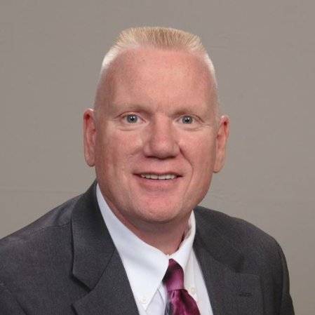 About Man in suit with short blond hair and a tie.